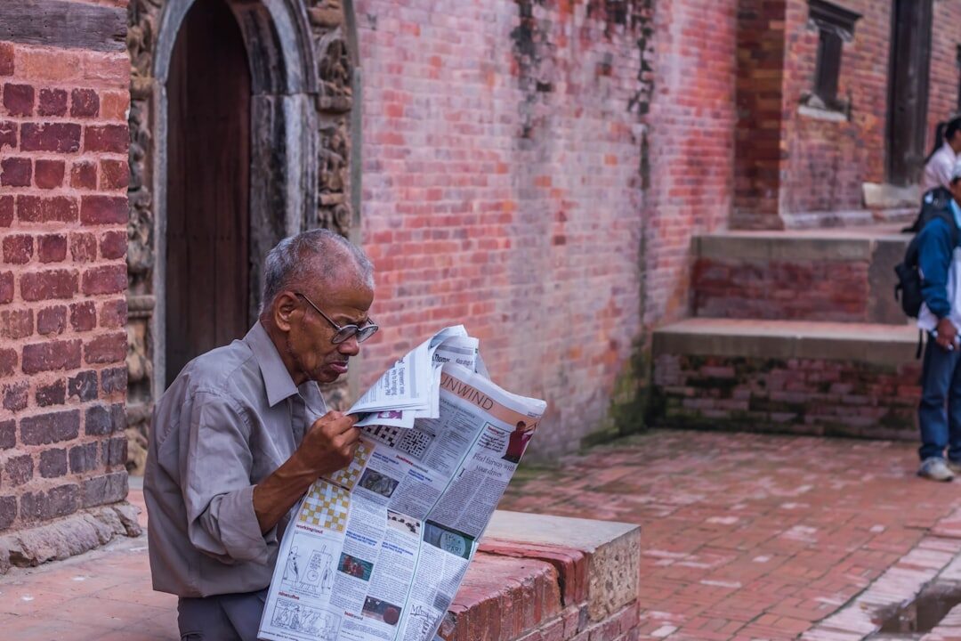 elderly people reading newspaper