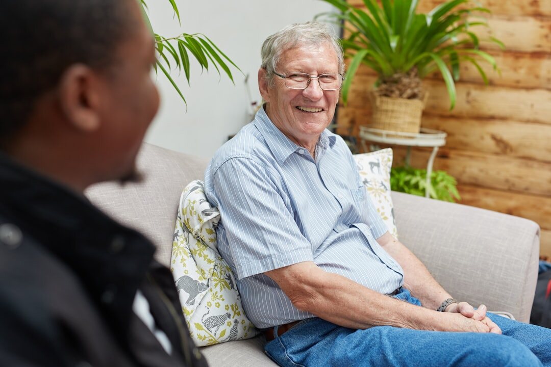 Croatian community center staff member assisting a senior member at a desk